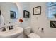 Well-lit half bathroom featuring a round mirror, framed art and a pedestal sink with stylish black hardware at 405 Buckskin Rd, Berthoud, CO 80513