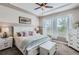 Serene bedroom with a white bed, soft colors, and natural light from the large windows at 405 Buckskin Rd, Berthoud, CO 80513