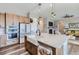 Open-concept kitchen features a large island, stainless appliances, a farmhouse sink and a view of the living room at 405 Buckskin Rd, Berthoud, CO 80513