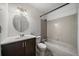Cozy bathroom with white tiling, dark vanity and a circular mirror at 904 Clover Cir, Lafayette, CO 80026
