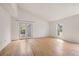 Bright living room featuring beautiful wood floors, white walls, a large window, and French doors to the backyard at 904 Clover Cir, Lafayette, CO 80026