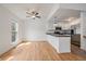 Bright and airy living space featuring beautiful wood floors, white walls, a modern, stainless steel kitchen, and ceiling fan at 904 Clover Cir, Lafayette, CO 80026