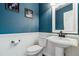 Clean bathroom with pedestal sink, white toilet, and teal walls at 1820 Cooper Ct, Castle Rock, CO 80109