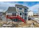 Two-story house with gray siding, red deck and stairs, and a fenced backyard at 1820 Cooper Ct, Castle Rock, CO 80109