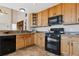 Kitchen with oak cabinets, black appliances, and granite countertops at 1820 Cooper Ct, Castle Rock, CO 80109