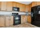 Modern kitchen featuring wood cabinets, black appliances, and granite countertops at 1820 Cooper Ct, Castle Rock, CO 80109