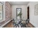 Stylish dining room with glass table, transparent chairs, exposed brick, and hardwood flooring at 1024 W 8Th Ave, Denver, CO 80204