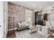Cozy living room features exposed brick wall, modern furnishings, and hardwood floors at 1024 W 8Th Ave, Denver, CO 80204