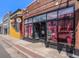 The storefront of 'Room for Friends' with vintage red curtains and large windows at 1024 W 8Th Ave, Denver, CO 80204
