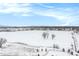 Panoramic aerial view of snow covered neighborhood with modern homes, park, and distant mountains at 6712 Zuni St, Denver, CO 80221