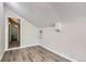 Bright bedroom featuring wood-look flooring, light gray walls, and an adjacent doorway to a bathroom at 3539 S Fairplay Way # 10, Aurora, CO 80014