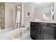 Clean bathroom featuring a shower-tub combo, a dark vanity, and neutral tiling for a relaxing and functional space at 22435 E Plymouth Cir, Aurora, CO 80016