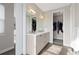Bathroom showcasing double sink vanity, large mirrors, and open doorway to walk in closet at 5026 S Platte River Pkwy, Littleton, CO 80123