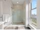 Bright bathroom with a glass-enclosed shower and large window showcasing natural light at 5026 S Platte River Pkwy, Littleton, CO 80123