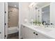 Bathroom showcasing double sink vanity with an open doorway to shower on the left at 5026 S Platte River Pkwy, Littleton, CO 80123