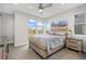 Bright bedroom with large windows, stylish furniture, ceiling fan and a modern accent painting at 5026 S Platte River Pkwy, Littleton, CO 80123