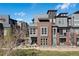 Modern multi-story townhome featuring a mix of brick and siding under a bright blue sky at 5026 S Platte River Pkwy, Littleton, CO 80123