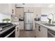 Modern kitchen featuring stainless steel appliances, white cabinets, and subway tile backsplash at 5026 S Platte River Pkwy, Littleton, CO 80123