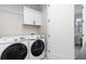 Laundry room featuring new front load washer and dryer, white cabinetry and a clothes rack at 5026 S Platte River Pkwy, Littleton, CO 80123