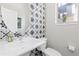 Stylish powder room featuring patterned accent wall, modern fixtures, and an oval mirror at 5026 S Platte River Pkwy, Littleton, CO 80123