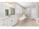 Modern bathroom with white cabinets, a soaking tub and neutral tile floors at 3101 Carabiner St, Castle Rock, CO 80108