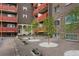 Apartment building courtyard featuring landscaped areas with gravel, trees, and small white stones at 3047 W 47Th Ave # 607, Denver, CO 80211