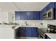 Contemporary kitchen with stainless appliances, white countertops and contrasting blue cabinets at 3047 W 47Th Ave # 607, Denver, CO 80211