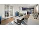 Open-concept living room with French doors and a partial view into the kitchen with blue cabinetry at 3047 W 47Th Ave # 607, Denver, CO 80211