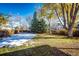 Large backyard with a mix of grass and fall foliage; some snow on the grass at 6454 S Nelson Way, Littleton, CO 80127