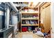 Unfinished basement with wood shelving filled with paints and supplies at 6454 S Nelson Way, Littleton, CO 80127