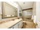 Bathroom featuring a shower and bathtub combo with a tiled vanity and decorative mirror at 6454 S Nelson Way, Littleton, CO 80127