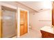 Neutral bathroom with a glass enclosed shower and wood toned storage at 6454 S Nelson Way, Littleton, CO 80127