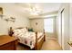 Cozy bedroom featuring a floral quilt, ceiling fan, and a window for natural light at 6454 S Nelson Way, Littleton, CO 80127