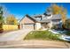 Charming two-story brick home with a well-maintained lawn and a two-car garage on a sunny day at 6454 S Nelson Way, Littleton, CO 80127