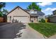 Charming brick home featuring a well-manicured lawn and a spacious two-car garage at 6454 S Nelson Way, Littleton, CO 80127