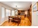 Bright kitchen and eating area, showcasing hardwood floors, cabinetry, and bay window at 6454 S Nelson Way, Littleton, CO 80127