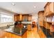 Open kitchen featuring wooden cabinets, granite countertops, stainless steel appliances, and hardwood flooring at 6454 S Nelson Way, Littleton, CO 80127