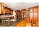 Well-appointed kitchen boasts granite countertops, wooden cabinets, stainless steel appliances, and hardwood floors at 6454 S Nelson Way, Littleton, CO 80127