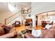 Inviting living room with hardwood floors, staircase, and leather furniture flowing into the adjacent dining area at 6454 S Nelson Way, Littleton, CO 80127