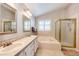 Bright main bathroom with dual sinks, soaking tub, and glass-enclosed shower at 6454 S Nelson Way, Littleton, CO 80127