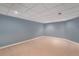 Unfurnished basement featuring blue accent walls, neutral carpet, and a drop ceiling at 7288 S Sundown Cir, Littleton, CO 80120