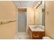 Bathroom featuring a wood vanity, single sink, framed mirror, and a glass enclosed shower at 7288 S Sundown Cir, Littleton, CO 80120