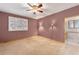 Bedroom featuring carpeted floors, ceiling fan, light sconces and window with a bathroom entry at 7288 S Sundown Cir, Littleton, CO 80120