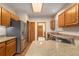 Well-lit kitchen featuring stainless steel refrigerator, wood cabinets, granite countertops and hardwood floors at 7288 S Sundown Cir, Littleton, CO 80120