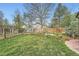 Spacious backyard with well-maintained lawn, trees, and a charming pergola at 4965 Dover St, Arvada, CO 80002
