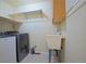 Well-lit laundry room featuring a washer, dryer, utility sink, and ample storage at 16873 Boreas Ct, Parker, CO 80134