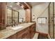 Bathroom features a dual sink vanity with granite counters and wood cabinets with glass enclosed shower and tile surround at 59 Gold Run Rd, Breckenridge, CO 80424
