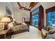 Vaulted ceiling Primary bedroom boasts beams, curtains, balcony, and scenic views of winter wonderland at 59 Gold Run Rd, Breckenridge, CO 80424