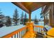 Mountain home deck features a stone column, wood railing and a stainless grill; winter wonderland view at 59 Gold Run Rd, Breckenridge, CO 80424