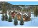 Beautiful mountain home with mature trees and snow covered landscape, set against a mountain backdrop at 59 Gold Run Rd, Breckenridge, CO 80424